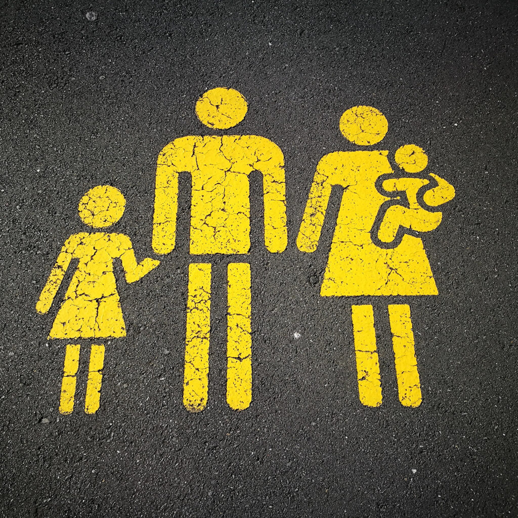 Bild på familj, målad med vägfärg, på asfalt
